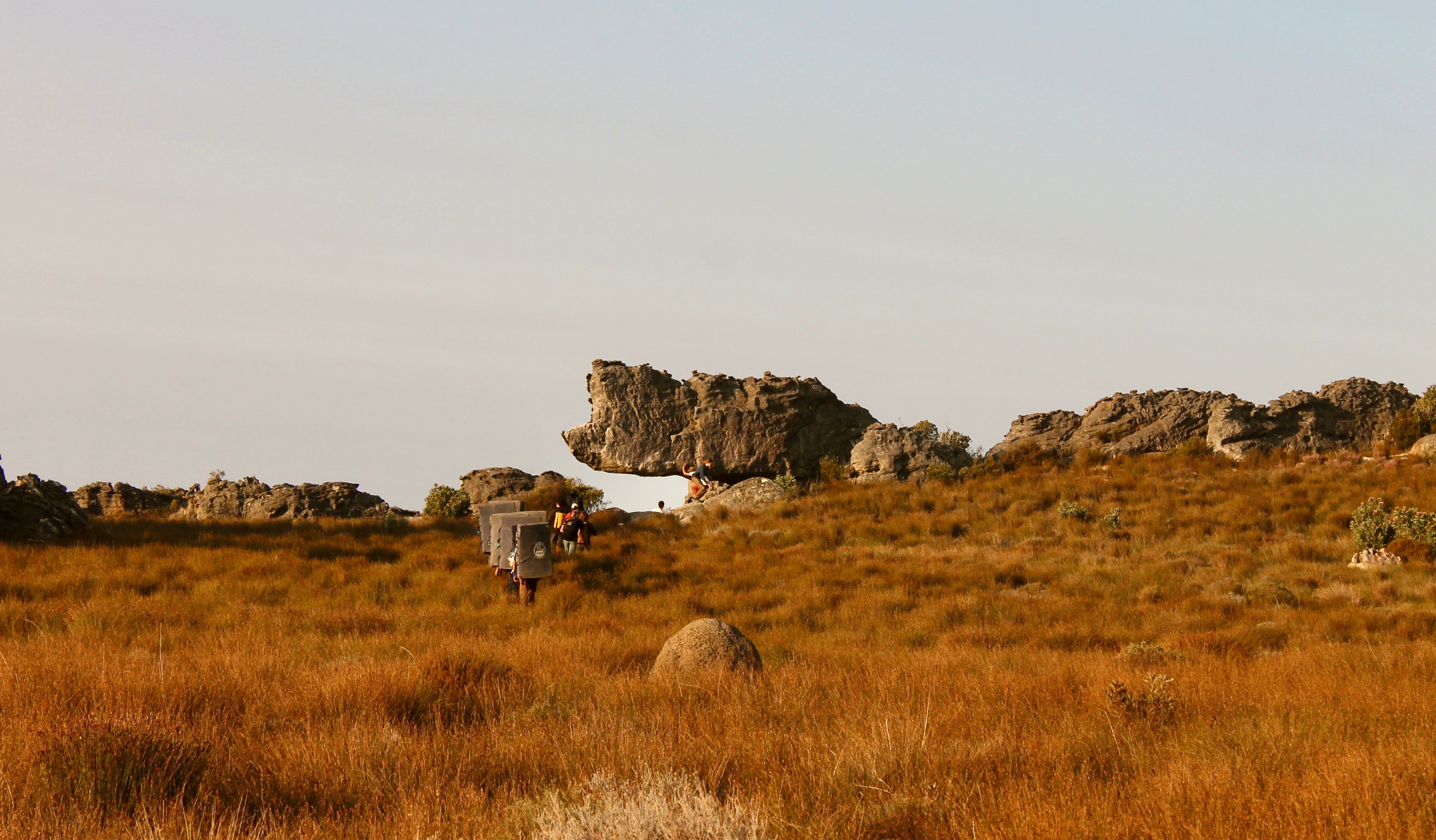 teenagers carrying boulder pads in south Africa going to climb The Rhino