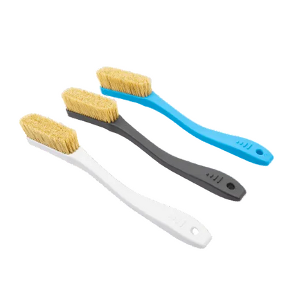 three plastic brushes with boar hair bristles used for rock climbing